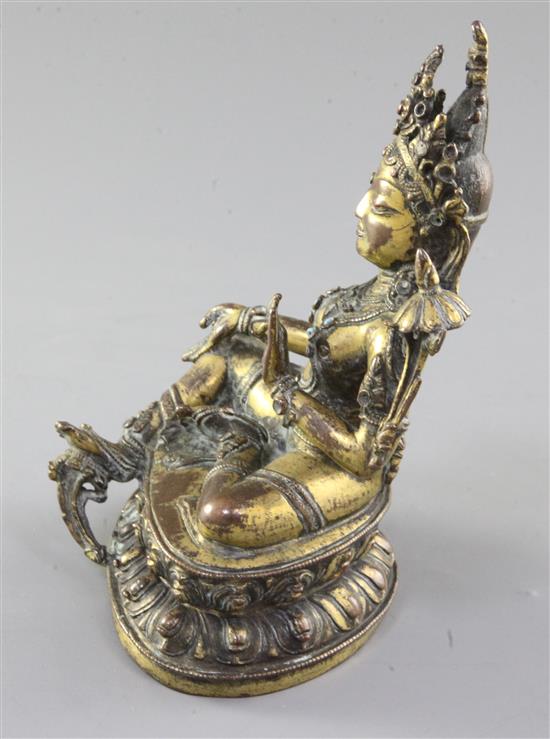 A Tibetan gilt copper alloy seated figure of Green Tara, 17th / 18th century, height 16.5cm